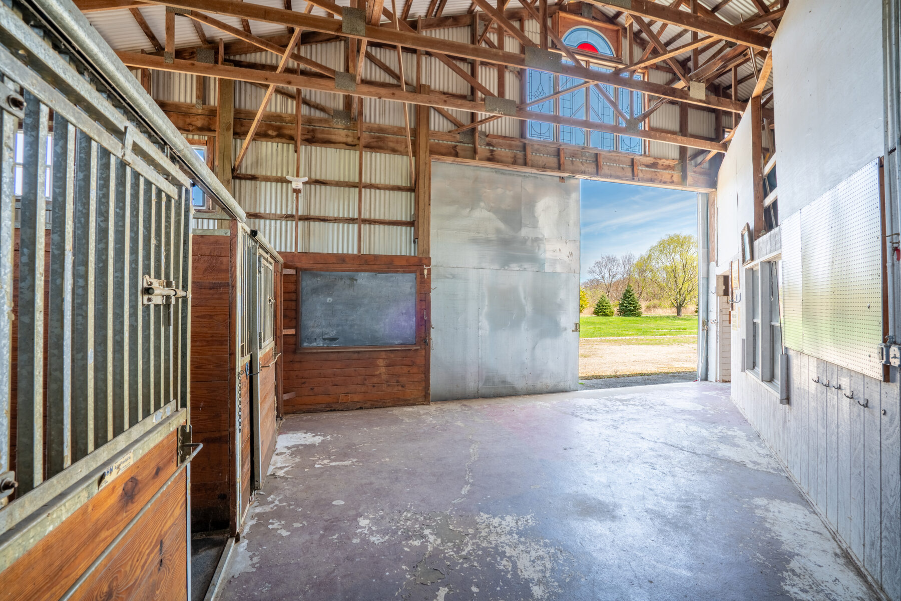 Stable end with the bay door open showing the property beyond